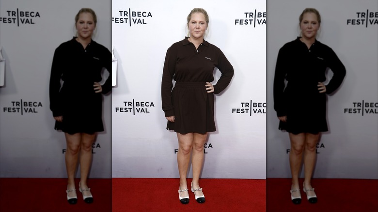 Amy Schumer con camisa y falda negras