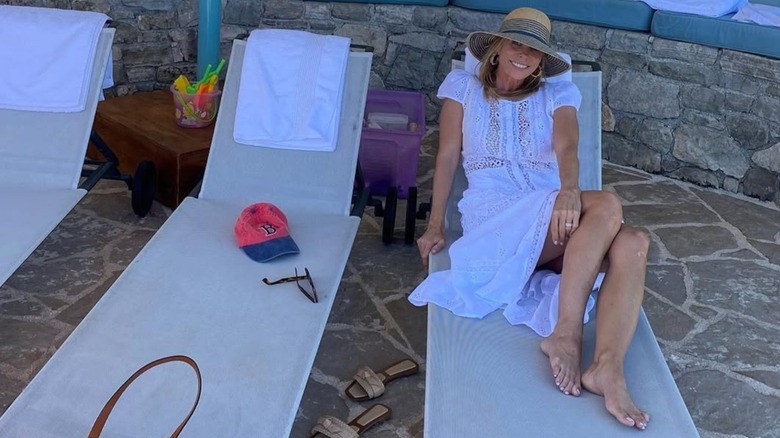 Cheryl Hines posando en Grecia con un vestido de encaje blanco