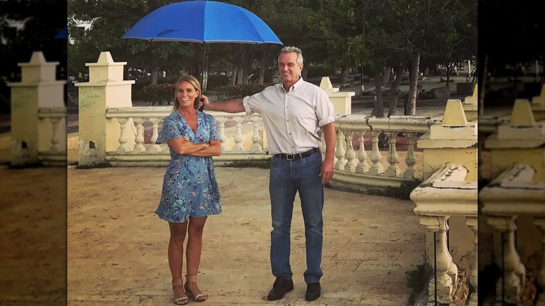 Cheryl Hines con Robert F. Kennedy Jr. sosteniendo un paraguas sobre ella