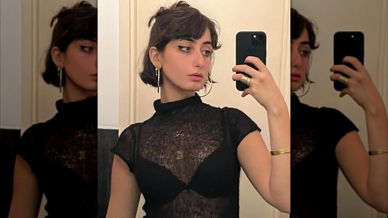 Rama Duwaji tomándose una selfie en el espejo con un top transparente