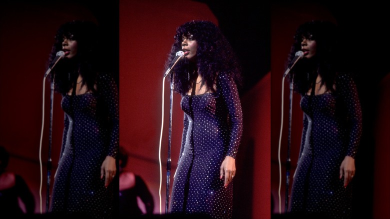 Donna Summer canta frente a un micrófono mientras está en el escenario