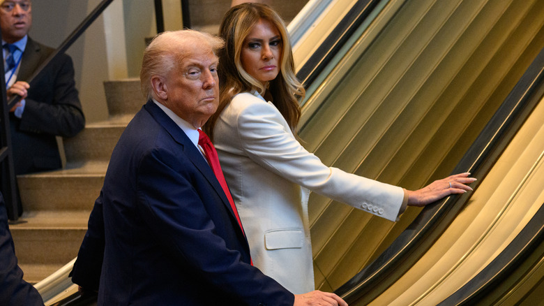 Donald y Melania Trump subiendo por las escaleras mecánicas