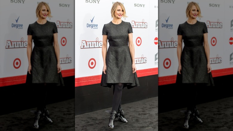 Cameron Diaz con un vestido gris de invierno, medias y botas brillantes.