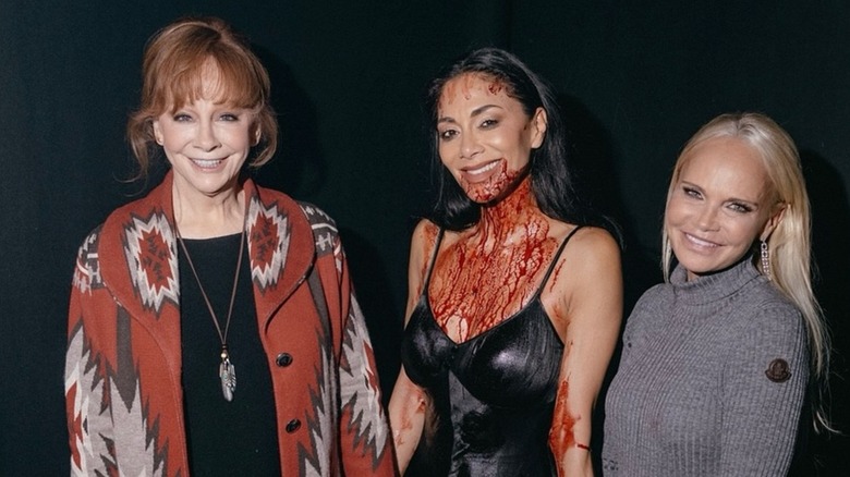Reba con el pelo desordenado posando junto a Kristin Chenoweth y Nicole Scherzinger.