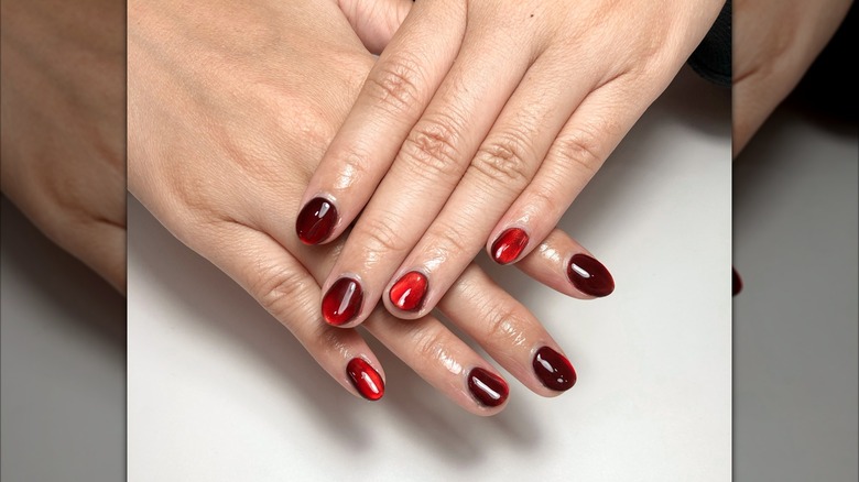 Uñas holográficas color rojo vino.