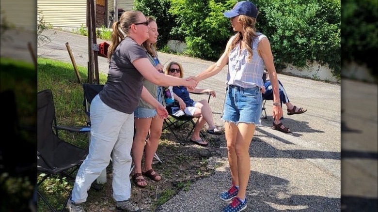 Kristi Noem le da la mano a una mujer el 4 de julio