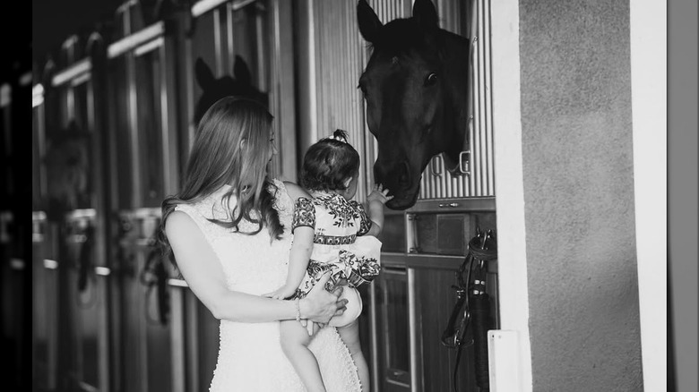 Jennifer Gates sostiene a su hija Leila mientras la pequeña toca un caballo en esta foto publicada en mayo de 2024 (2024)