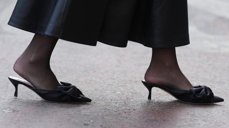 Una mujer que llevaba mulas anticuadas con tacones.