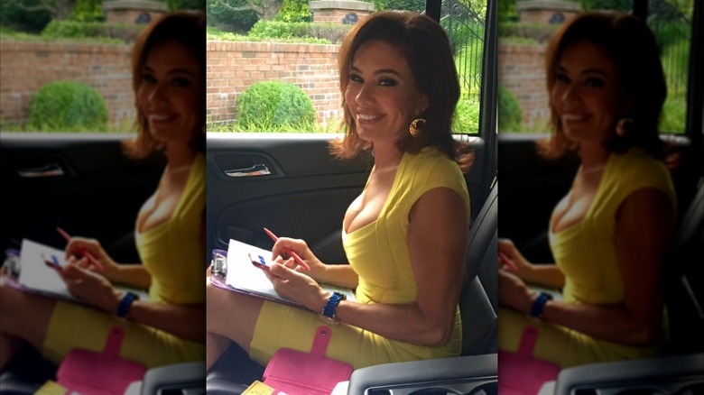 Jeanine Pirro sentada en la parte trasera de un auto trabajando