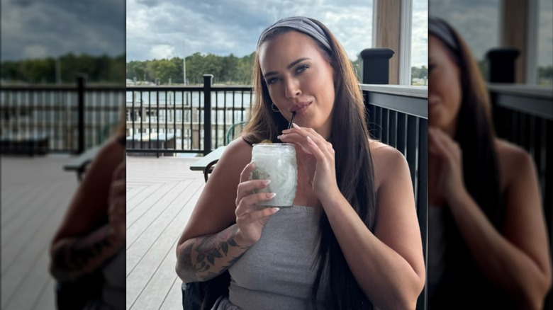Chelsea Blackwell bebe una bebida al aire libre de un restaurante