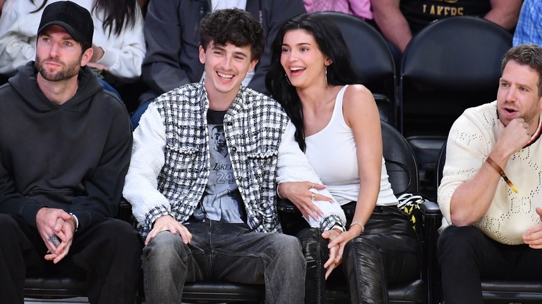 Timothée Chalamet y Kylie Jenner riéndose entre la multitud en un evento deportivo