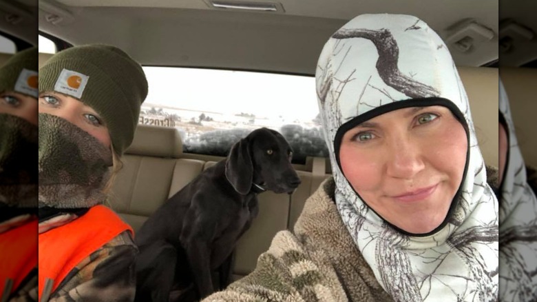 Kristi Noem tomándose una selfie en su auto con su hija y su perro