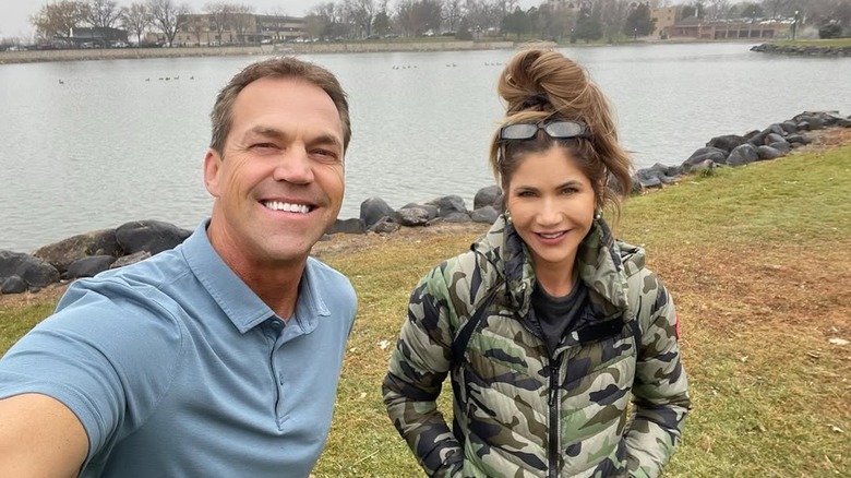 Bryon y Kristi Noem tomándose una selfie frente a un lago