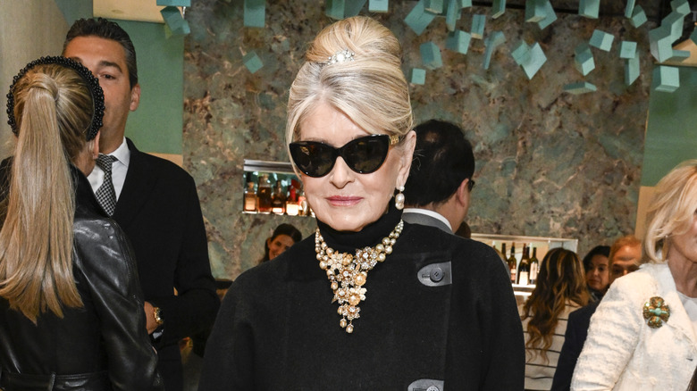 Martha Stewart posando con gafas de sol y un jersey de cuello alto con un collar llamativo