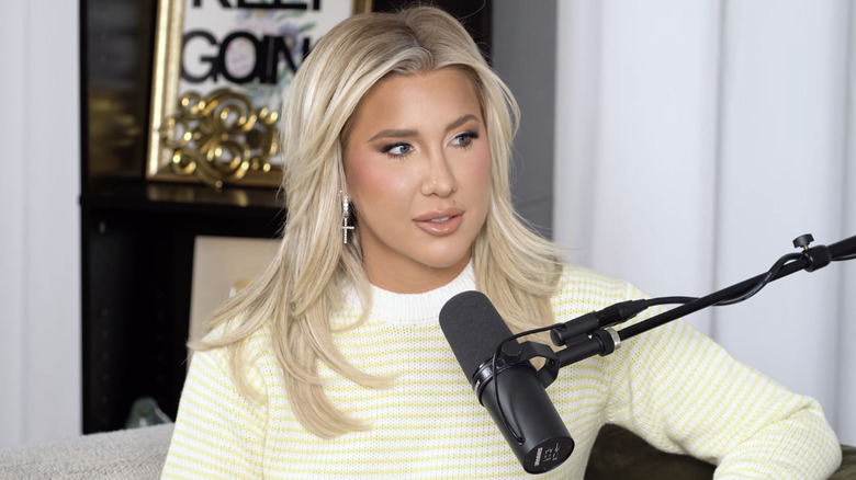 Savannah Chrisley habla por un micrófono mientras presenta su podcast