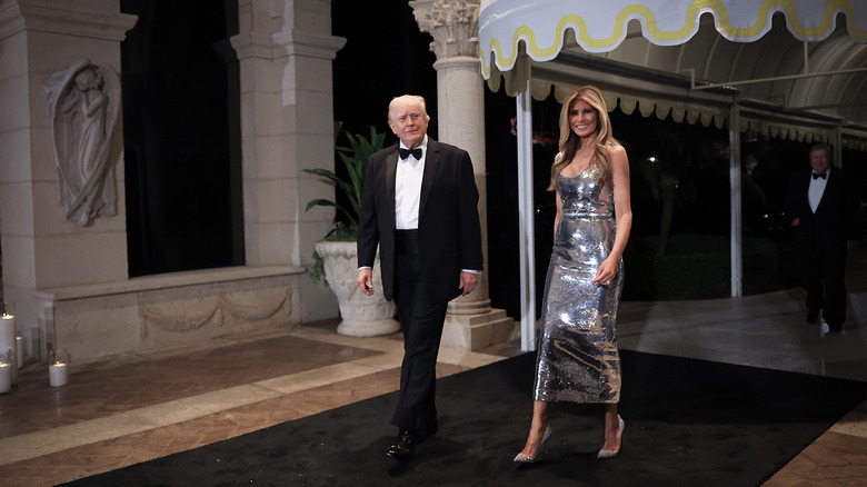 Melania Trump luciendo un vestido plateado y paseando con Donald Trump