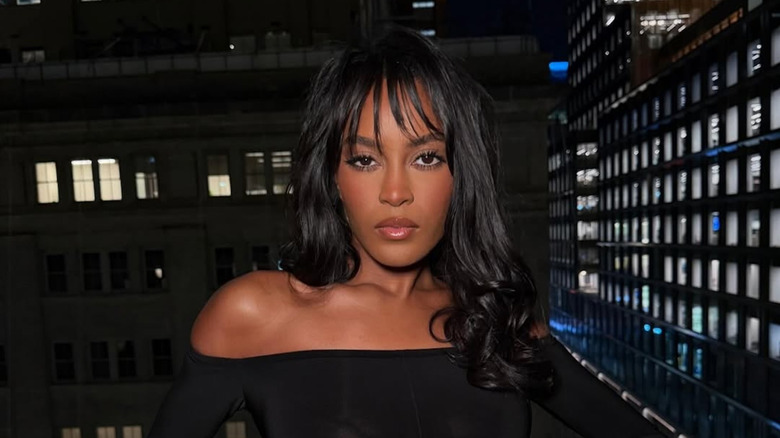 Ciara Miller posando con pelo rizado y flequillo ralo