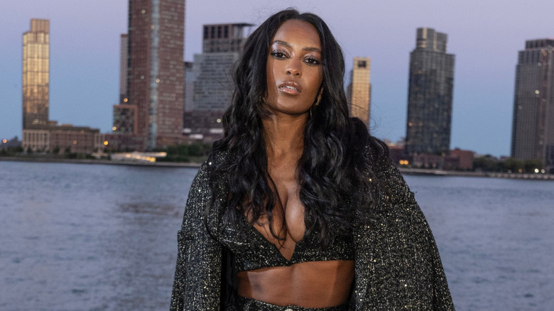 Ciara Miller posando con el pelo rizado frente al río Hudson