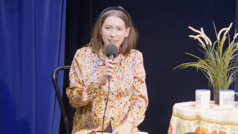 Eden Sher habla por un micrófono mientras está en el escenario para un show en vivo