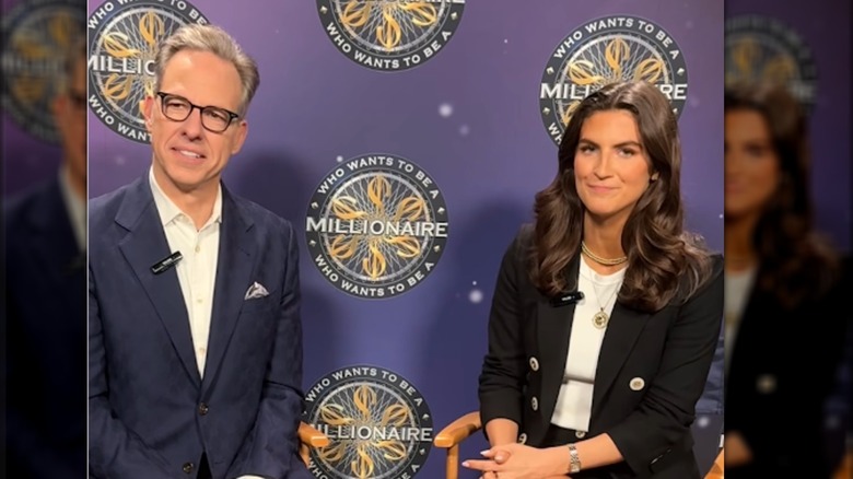 Collins se sienta junto a Jake Tapper para una entrevista. Tapper es un hombre blanco mayor con cabello corto y gris y gruesos anteojos negros. Lleva un traje azul marino con botones blancos. Collins lleva una chaqueta negra con una minifalda a juego, una camiseta blanca y algunos collares dorados. Dos están hechos de gruesas cuentas de oro y uno presenta un gran colgante circular con un motivo de sol en una fina cadena de oro.