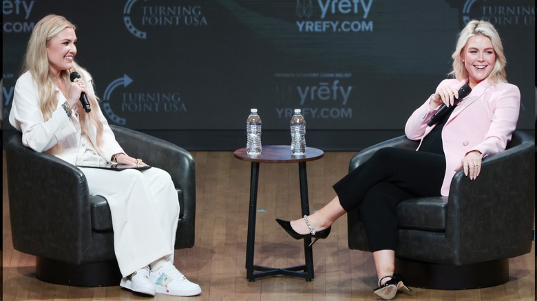 Erika Kirk y Karoline Leavitt sentadas una frente a la otra en el escenario del evento Turning Point USA.