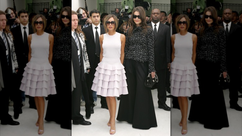 Victoria Beckham y Katie Holmes posando para las cámaras en el desfile de Chanel de primavera/verano de 2007 durante la semana de la moda de París (2006)