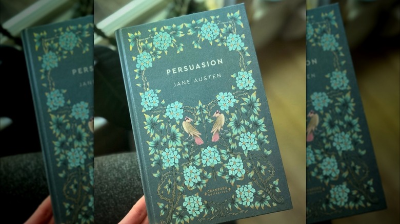 Una mano sosteniendo una copia de 'Persuasión' de Jane Austen