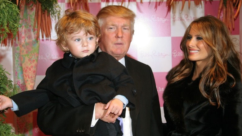 Donald Trump sostiene a su hijo Barron mientras su madre Melania observa