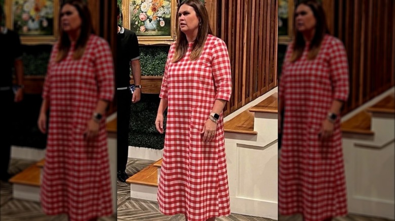 Sarah Huckabee Sanders con un vestido largo de cuadros rojos y blancos
