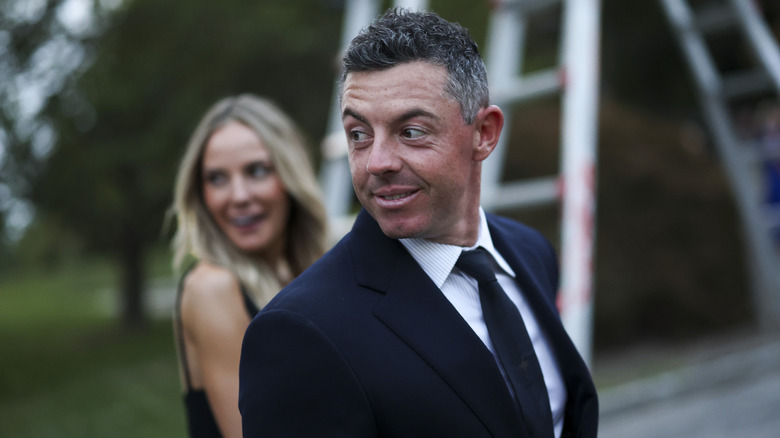 Rory McIlroy mira a su derecha mientras toma de la mano a su esposa Erica Stoll.