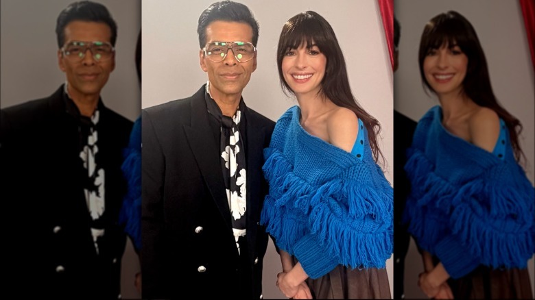 Anne Hathaway posa con el periodista Karan Johar. Lleva un suéter azul brillante con hombros descubiertos cubierto con flecos azules.