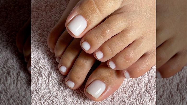 Pedicura con esmalte de uñas blanco lechoso.