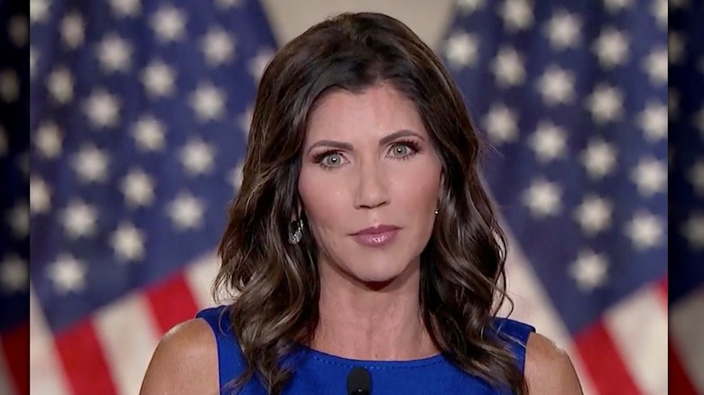 Kristi Noem habla desde un podio mientras se dirige a los oyentes