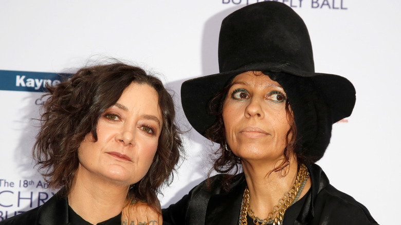 Sara Gilbert posa para la cámara mientras Linda Perry apoya su brazo sobre su hombro en una alfombra roja