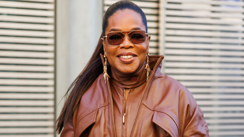Oprah Winfrey con un mono de cuero y gafas de sol sonriendo