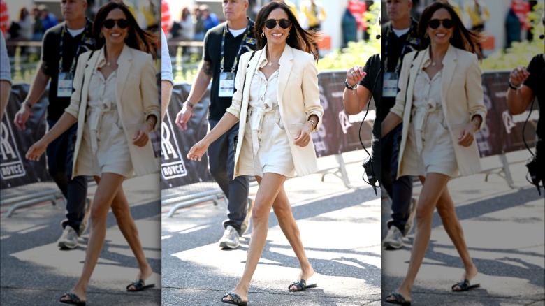 Meghan Markle caminando en los Invictus Games 2023. Lleva una chaqueta blanca con un mono corto blanco y chanclas negras.