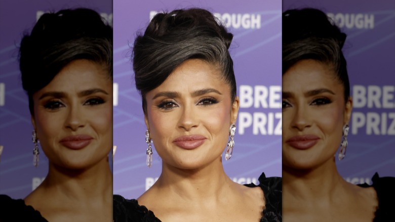 Salma Hayek con vestido negro y elegante recogido dejando ver sus canas
