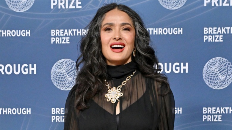 Salma Hayek posando con un top negro transparente dejando ver sus grises