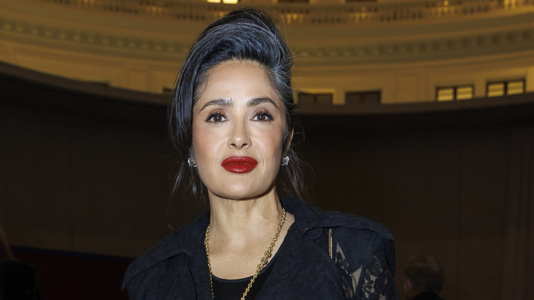 Salma Hayek con vestido negro y elegante recogido dejando ver sus canas