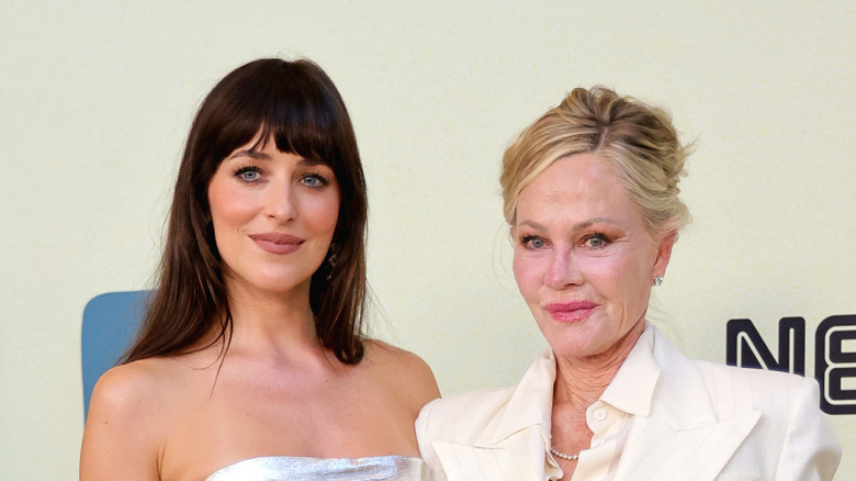 Dakota Johnson y Melanie Griffith posan juntas sonriendo en la alfombra roja de una premiere