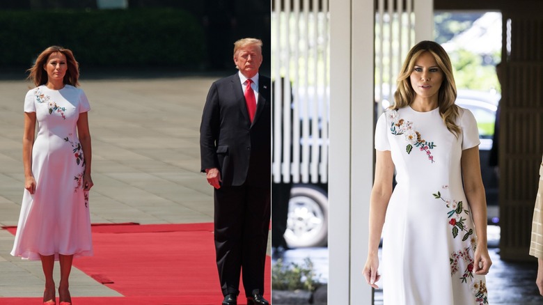 Melania Trump de pie con Donald Trump con un vestido de flores blanco