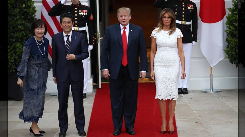 Melania Trump con un vestido de encaje blanco con Donald Trump y el primer ministro de Japón y su esposa