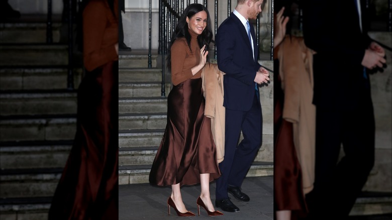 Meghan Markle luciendo un traje marrón monocromático con el pelo suelto.