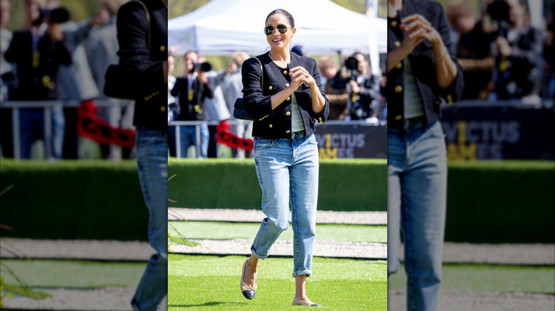 Meghan Markle vistiendo una chaqueta de tweed negra con jeans de lavado claro y bailarinas Chanel.