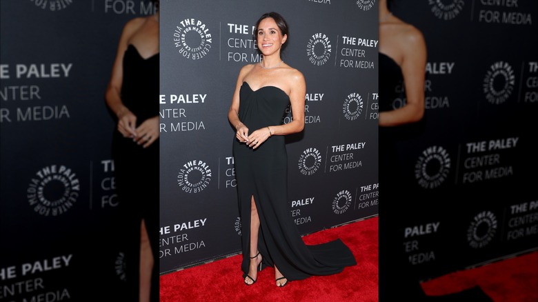 Meghan Markle con un vestido negro sin tirantes y sandalias de tacón negras en la Gala de Honores de Otoño Paley 2024