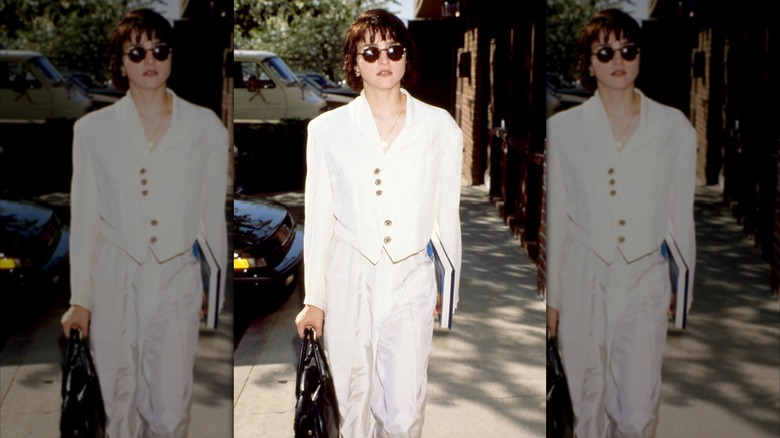 Madonna con una chaqueta y pantalones blancos cortos.