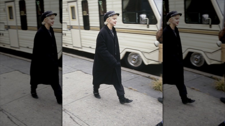Madonna en el set de "¿Quién es esa chica?" vistiendo un abrigo negro y una gorra de vendedor de periódicos