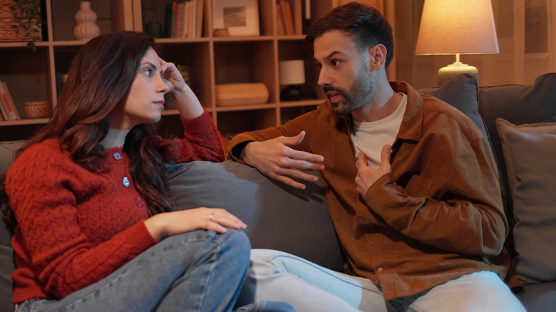 pareja teniendo una discusión seria en el sofá