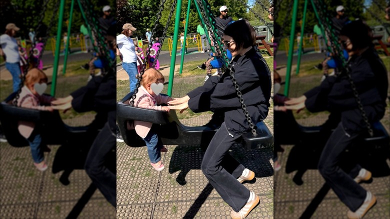 Lily Collins y su hija juegan en un parque.