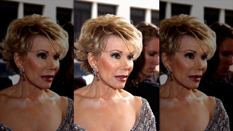 Joan Rivers fotografiada con un vestido plateado con pelo corto y aretes colgantes.